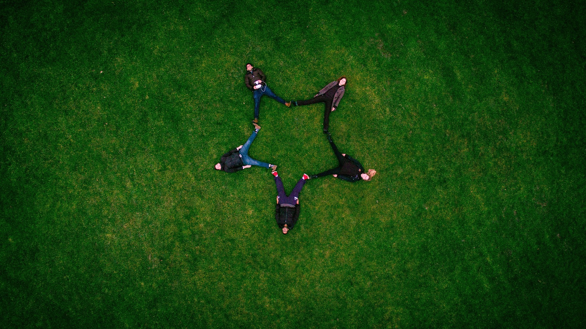 Vu du ciel, cinq amis allongés dans l'herbe forment une étoile - Image par Pexels de https://pixabay.com/fr/photos/adultes-copains-formation-gazon-1853483/