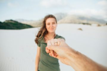 Une fille floue en arrière plan montre sa main portant une bague de fiançaille tenue par la main de son fiancé - Photo de Neal E. Johnson sur https://unsplash.com/fr/photos/femme-portant-un-haut-vert-se-tenant-la-main--TXYLc5lEuM