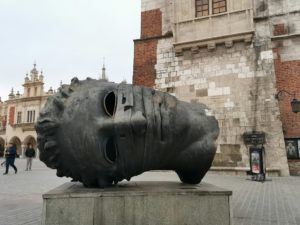 sculpture d'Igor Mitoraj au centre de Krakovie - Photo de Patryk sur https://unsplash.com/fr/photos/une-grande-oeuvre-dart-posee-sur-un-bloc-de-ciment-XYGKQZ91jio