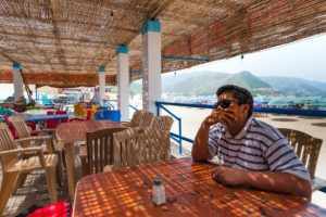 Un homme attablé au café de la plage à Bejaia en Algérie - Image par Loyloy Thal de https://pixabay.com/fr/photos/caf%C3%A9-plage-boulimat-bejaia-alg%C3%A9rie-2437917/