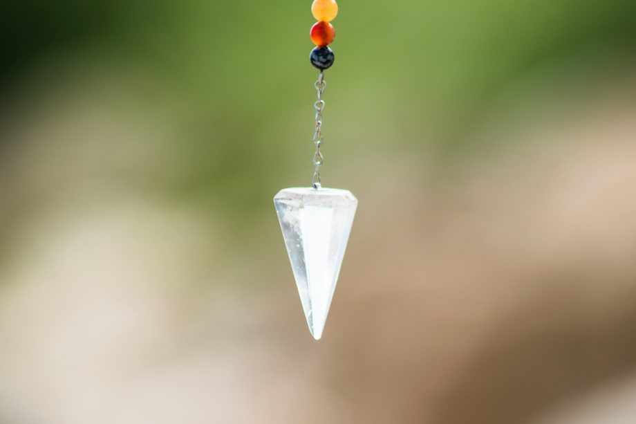 Un pendule en cristal de roche, censé nous guider - Photo de Frames For Your Heart sur https://unsplash.com/fr/photos/pendentif-diamant-argent-avec-perles-rouges-bleues-et-jaunes-Z4Dtkci_Enk