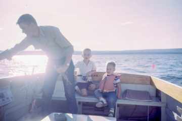 Un père emmène ses enfants à la pêche sur une barque - Photo de Les Anderson sur https://unsplash.com/fr/photos/homme-tenant-un-poisson-gris-debout-a-cote-de-deux-garcons-assis-sur-des-sieges-de-bateau-9bpwQIKnJYY
