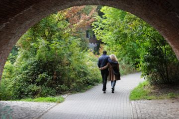 Un couple marche en se tenant par la taille sur une route qui passe sous un pont et va dans la nature - Image par Rainer Küster de https://pixabay.com/fr/photos/pont-peu-paire-homme-femme-525615/