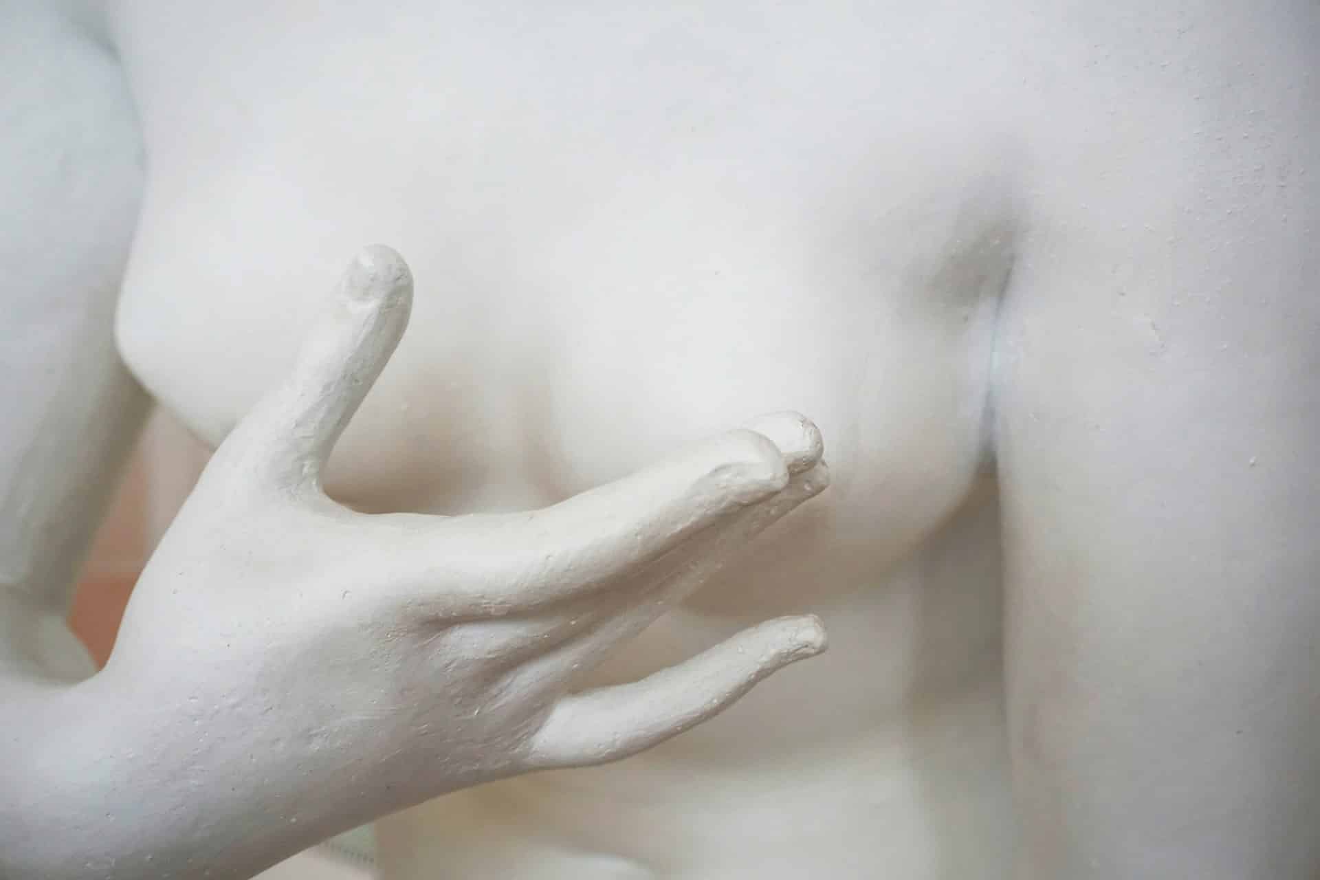 Une sculpture en plâtre avec une main devant des seins - Photo de Victoria Strukovskaya sur https://unsplash.com/fr/photos/figurine-de-femme-nue-fu3UqXTbGcs