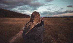 Une jeune femme avec des cheveux longs, vue de dos, dans un paysage d'automne - Photo de Vadim Sadovski sur Unsplash
