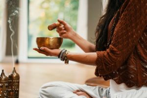 Bol tibétain et encens en action par une femme - Photo de Conscious Design sur https://unsplash.com/fr/photos/femme-en-pull-en-tricot-marron-tenant-une-tasse-en-ceramique-marron-VsI_74zRzAo