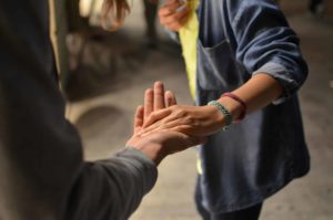 Deux amis se saluent - Photo de Rémi Walle sur https://unsplash.com/fr/photos/homme-et-femme-se-tenant-la-main-dans-la-rue-UOwvwZ9Dy6w