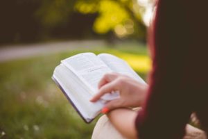 Une jeune femme vue de dos en train de lire la Bible dans un parc - Photo de Ben White sur https://unsplash.com/fr/photos/photographie-de-mise-au-point-selective-dune-personne-lisant-un-livre-gGbuETcoKjw