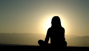 femme assise en tailleur à contre jour regarde le soleil - Photo par formulaire https://pxhere.com/fr/photo/892289