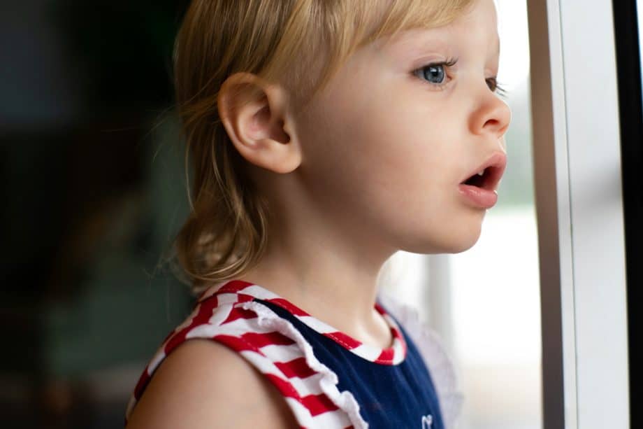 une petite fille regarde par la fenêtre en s'étonnant de quelque chose - Photo de Jeremiah Lawrence sur https://unsplash.com/fr/photos/fille-en-debardeur-bleu-et-blanc-IXiGMtCrQPg