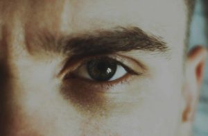 Un oeil qui regarde attentivement, avec l'air un petit peu sévère - Photo de Abbat sur https://unsplash.com/fr/photos/oeil-de-personnes-dans-la-photographie-en-gros-plan-MjTUbkC12qg