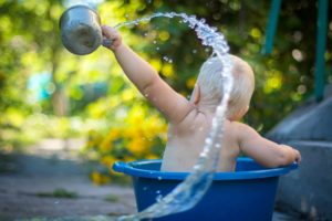 enfant jouant avec de l'eau - Photo de Lubomirkin sur https://unsplash.com/fr/photos/enfant-soulevant-la-louche-deau-XKpPsuuGE_Q