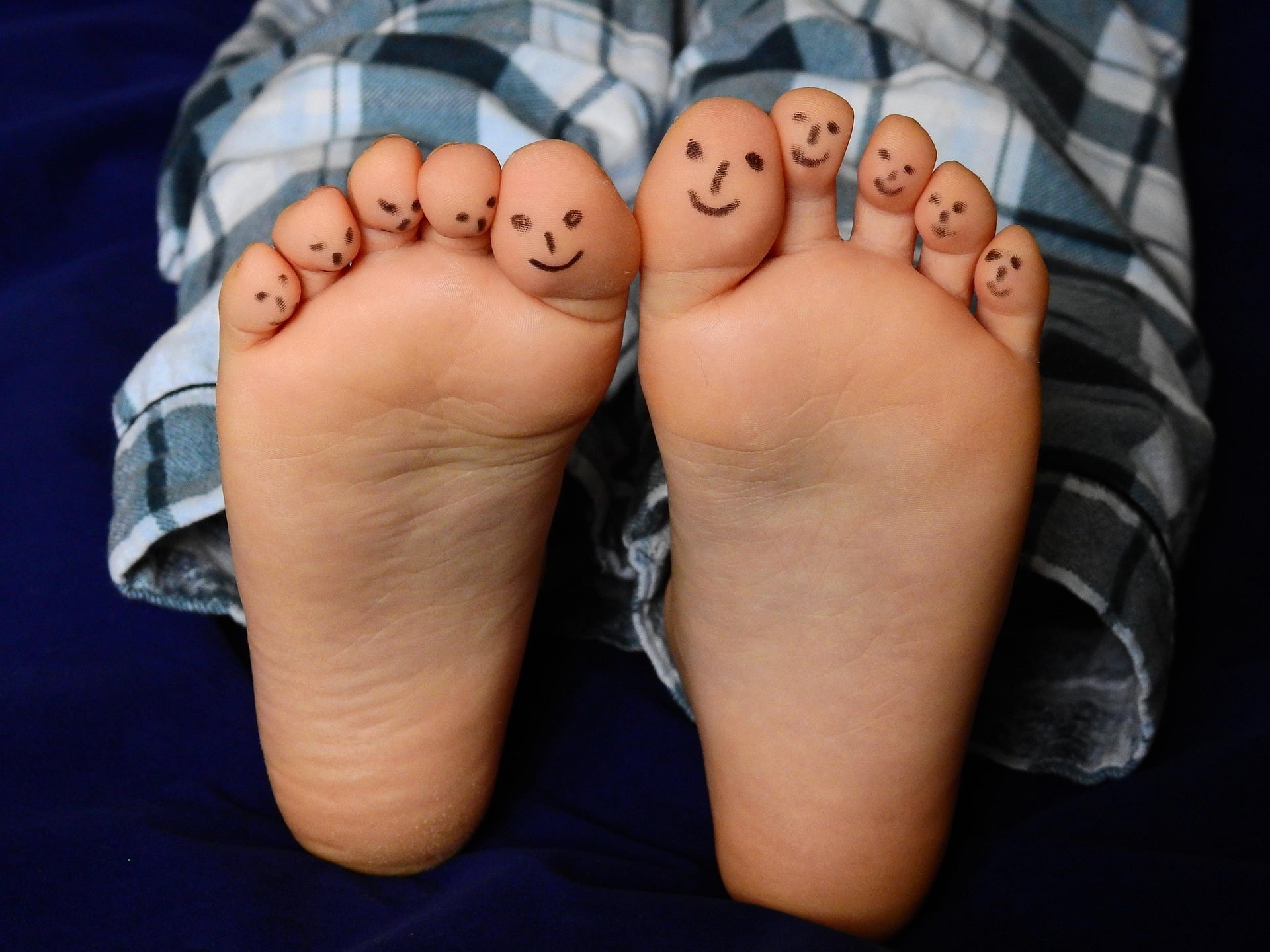 Deux petits pieds d'un enfant avec des sourires dessinés sur les doigts - Image par Bruno de https://pixabay.com/fr/photos/pieds-les-orteils-pieds-nus-enfant-2358333/