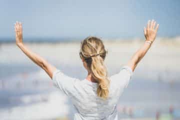 Une femme tend les bras en signe de bénédiction sur la ville - Photo de Guillaume de Germain sur https://unsplash.com/fr/photos/femme-en-chemise-blanche-a-manches-longues-portant-des-lunettes-a-monture-marron-v8pELaoQBxQ
