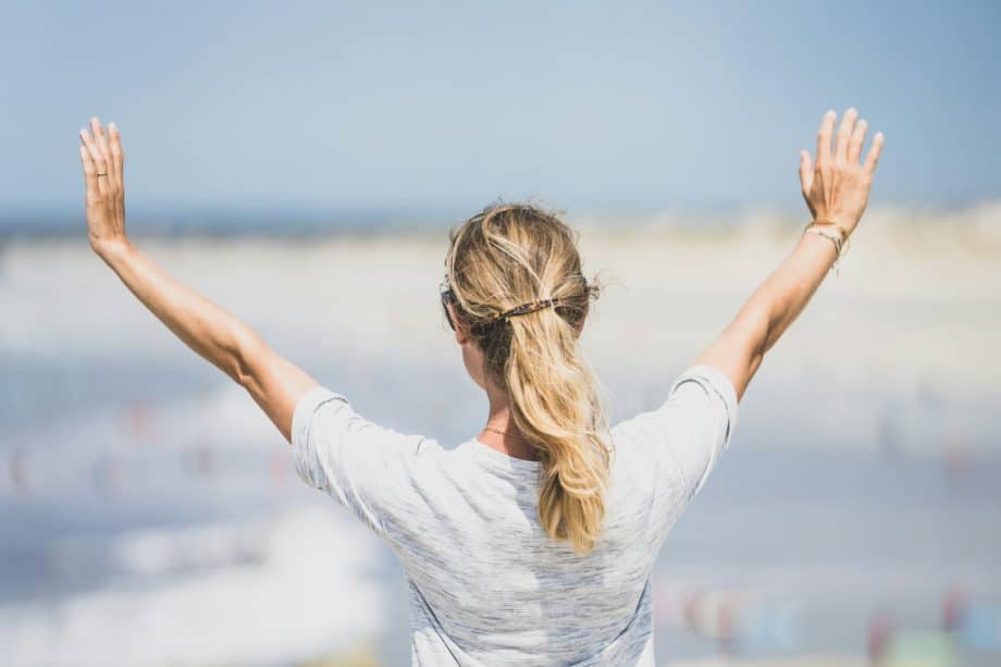 Une femme tend les bras en signe de bénédiction sur la ville - Photo de Guillaume de Germain sur https://unsplash.com/fr/photos/femme-en-chemise-blanche-a-manches-longues-portant-des-lunettes-a-monture-marron-v8pELaoQBxQ