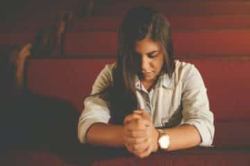 Une jeune femme seule dans une église vide prie - Photo de Naassom Azevedo sur https://unsplash.com/fr/photos/femme-priant-a-linterieur-de-leglise-NWu79O4kekw