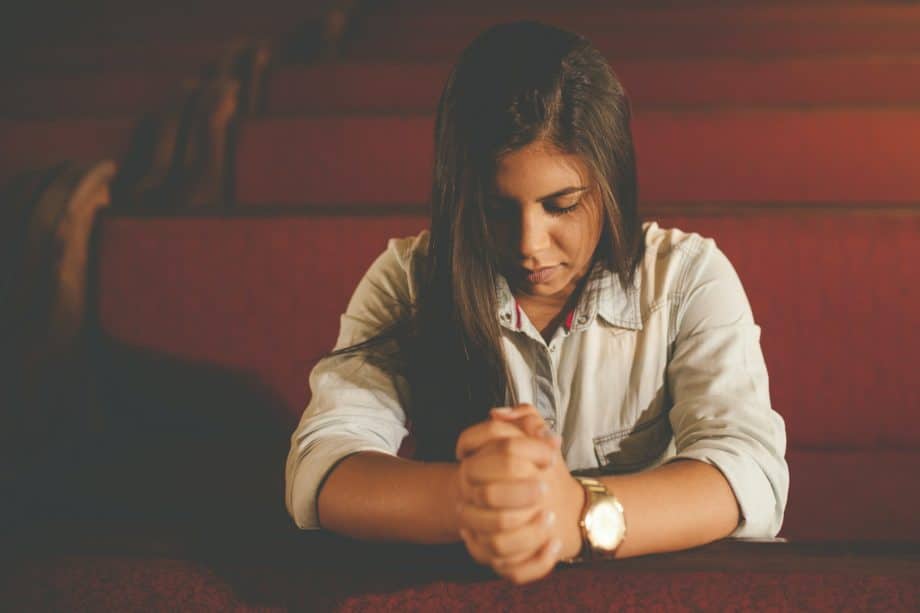 Une jeune femme seule dans une église vide prie - Photo de Naassom Azevedo sur https://unsplash.com/fr/photos/femme-priant-a-linterieur-de-leglise-NWu79O4kekw