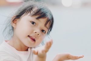 Une petite fille en train de discuter avec des mouvements de mains - Image par ymyphoto de https://pixabay.com/fr/photos/b%C3%A9b%C3%A9-fille-portrait-enfant-enfance-6578335/