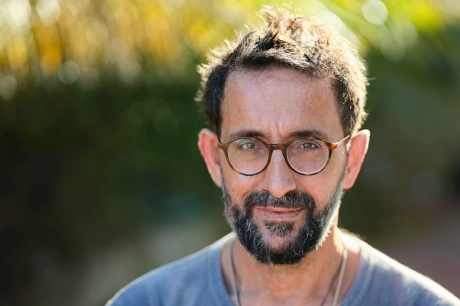 Un homme d'une cinquantaine d'années souriant sur fond de nature - Photo de Christian Buehner sur https://unsplash.com/fr/photos/homme-en-chemise-bleue-a-col-rond-portant-des-lunettes-a-monture-noire-zYD6ou1Qj10