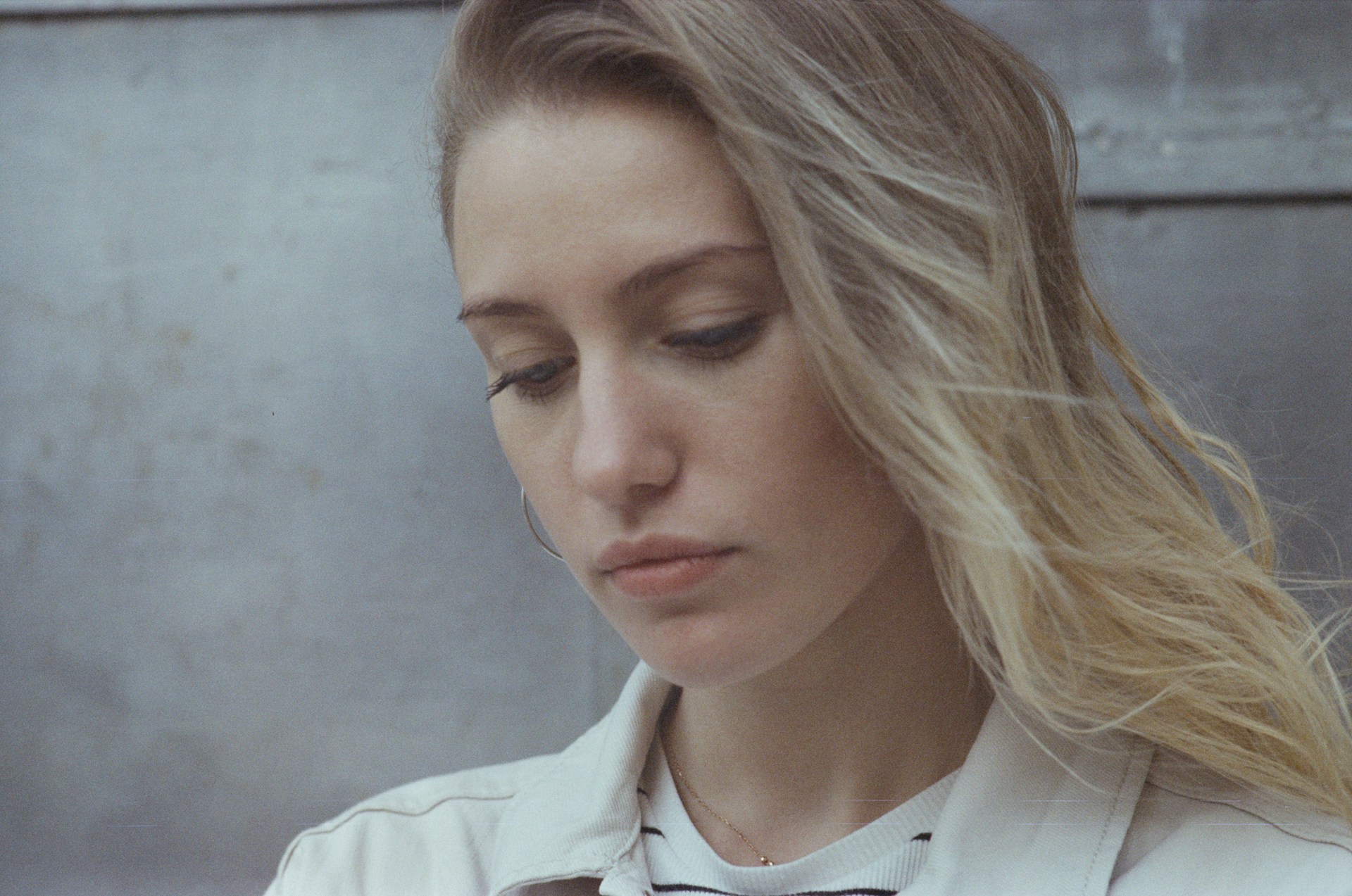 jeune femme pensive - Photo de Daria Kraplak sur https://unsplash.com/fr/photos/une-femme-en-veste-blanche-regardant-son-telephone-portable-8jsNNELDdI4