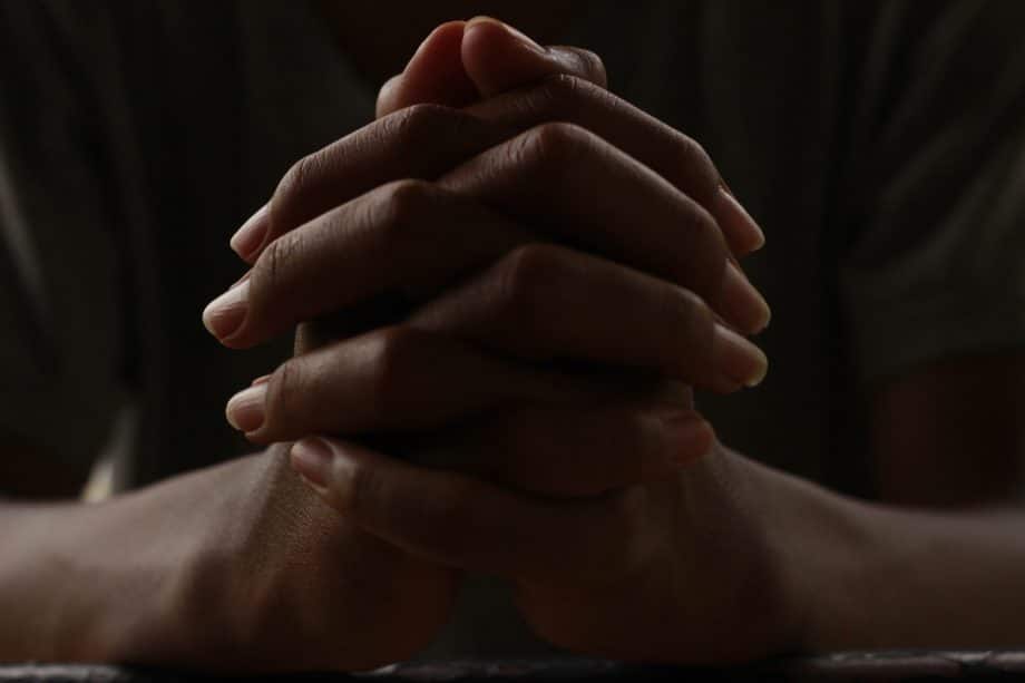 Photo de mains croisées en signe de prière, sur un fond noir - Image par Tep Ro de https://pixabay.com/fr/photos/mains-prier-v%C3%A9n%C3%A9ration-croyance-5441201/