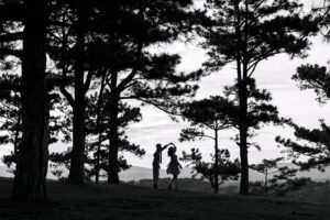 Un couple danse sous des grands pins, illustrant l'amour et le souffle de l'Esprit - Image par Hoàng Đông Trịnh Lê de https://pixabay.com/fr/photos/amour-nature-romance-coupler-6706324/