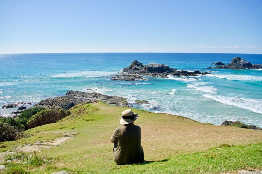 Photo d'une femme portant un chapeau, vue de dos, re reposant assise dans l'herbe, et regardant la mer - Image par Siggy Nowak de https://pixabay.com/fr/photos/repos-tranquille-outlook-relaxation-3563586/