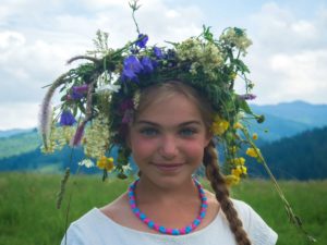 fille joyeuse qui s'est fabriqué une grosse couronne de fleurs - Photo de Michael Walk sur https://unsplash.com/fr/photos/femme-portant-un-haut-blanc-a-col-rond-nW3W3fLWHY0