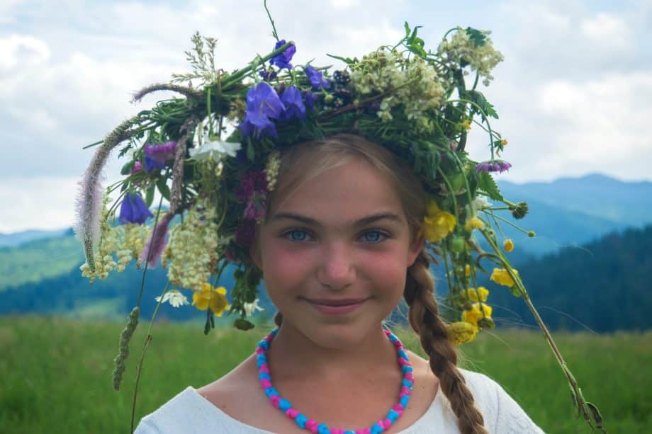 fille joyeuse qui s'est fabriqué une grosse couronne de fleurs - Photo de Michael Walk sur https://unsplash.com/fr/photos/femme-portant-un-haut-blanc-a-col-rond-nW3W3fLWHY0