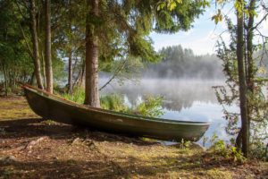 Un bateau prêt à être emprunté pour naviguer sur un lac calme, avec du soleil et une légère brume, et de beaux arbres - Image par Tapani Hellman de https://jecherchedieu.ch/wp-content/uploads/2025/09/boat-6579441_1920.jpg