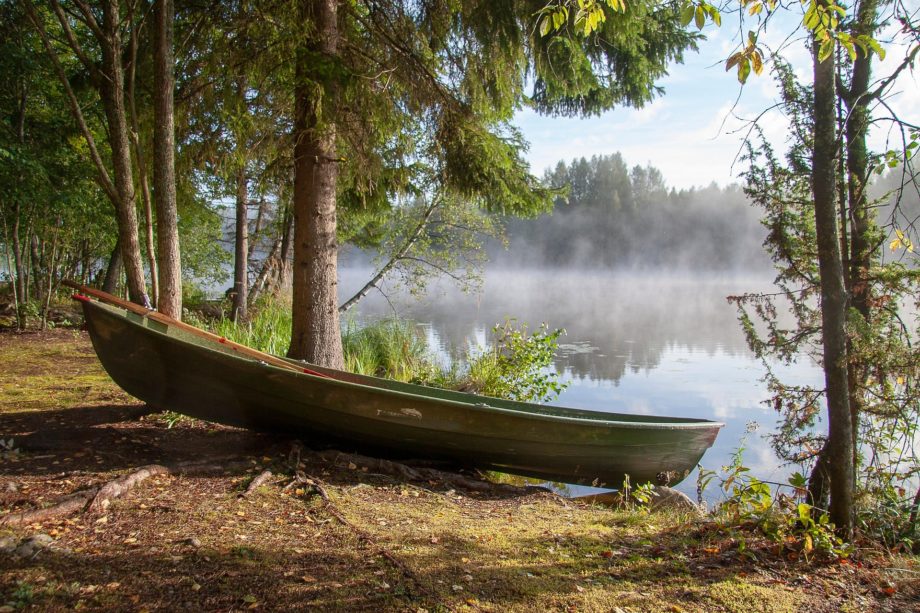 Un bateau prêt à être emprunté pour naviguer sur un lac calme, avec du soleil et une légère brume, et de beaux arbres - Image par Tapani Hellman de https://jecherchedieu.ch/wp-content/uploads/2025/09/boat-6579441_1920.jpg
