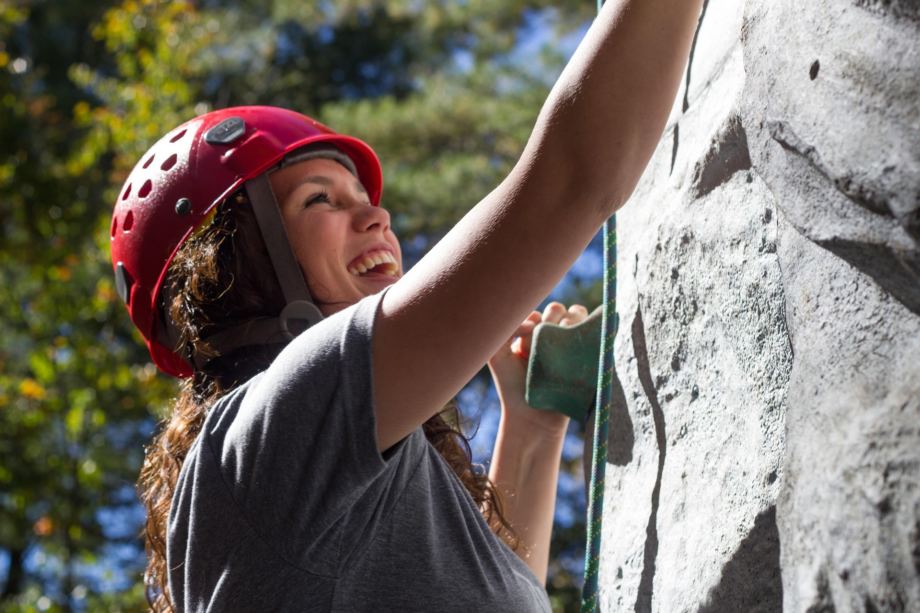 Jeune femme joyeuse portant un casque rouge et assurée par des cordes en train d'escalader une parois - Image par Taylor Burnett de https://pixabay.com/fr/photos/escalade-fille-amusement-content-525768/