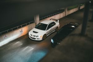 Deux voitures identiques, l'une blanche et l'autre noire font la course dans la nuit - Photo de Erik Mclean sur https://unsplash.com/fr/photos/bmw-m-3-coupe-blanc-et-noir-fDFSED3hKbE