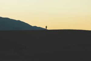 une personne vue de loin en marche sur la crête d'une montagne, au crépuscule - Image by Pexels from https://pixabay.com/photos/man-mountain-person-silhouette-1834857/