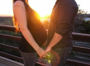 femme enceinte et homme face à face au coucher du soleil - Image par Jennifer Bayers de https://pixabay.com/fr/photos/coupler-enceinte-maman-1126637/