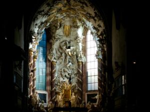 Une ouverture dans uen église baroque, apportant lumière et mystères - Photo de Denis Denis sur https://unsplash.com/fr/photos/autel-baroque-orne-avec-un-eclairage-dramatique-lNjSgITpTVM