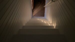 Un rayon de lumière perce sur un escalier descendant entre des murs modernes - Photo de Justus Hinz sur https://unsplash.com/fr/photos/un-escalier-menant-a-un-couloir-UZXtxxDwp4I