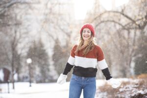 Une jeune femme en pull et moufles jouant dans la neige - Image par Ana Krach de https://pixabay.com/fr/photos/femme-maquette-portrait-pose-style-4707545/