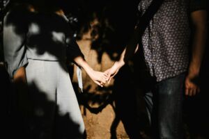 Une femme et un homme se tiennent par la main, dans l'ombre - Photo de Andrew Neel sur https://unsplash.com/fr/photos/homme-et-femme-se-tenant-la-main-usVeI1ZdMb8