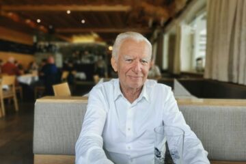 Homme âgé en forme et souriant à la table d