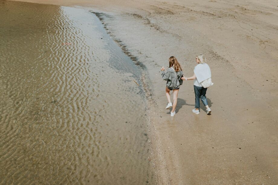 Une grand-mère marche avec sa petite fille sur le bord de la mer - Photo de Sandro Gonzalez sur https://unsplash.com/fr/photos/un-couple-de-femmes-marchant-sur-une-plage-Epnr9fhU4xM