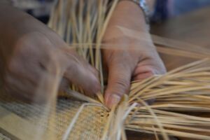 mains d'un artisant tressant de la paille pour faire un tissus - Photo de Wei-Cheng Wu sur https://unsplash.com/fr/photos/personne-qui-tisse-de-la-paille-beige-R7lSwItK0LE