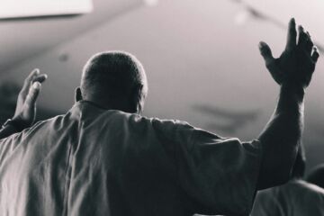 Un homme en chemise simple vu de dos donnant un geste de bénédiction - Photo de Matthew Pablicosur https://unsplash.com/fr/photos/homme-aux-bras-leves-en-signe-dadoration-xk8K_vInhAU