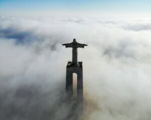 Statue du Christ à Lisbonne au Portugal, au dessus d'une mer de nuages - Photo de Motoki Tonnsur https://unsplash.com/fr/photos/christ-redempteur-couvert-de-nuages-pendant-le-jour-vV1a1Leq-dQ