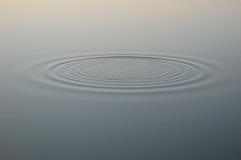une onde unique et subtile se propageant à la surface d'une eau parfaitement calme. Cela symbolise le chuchotement divin au fond de l'âme tranquille - Photo de Javier Virues-Ortegasur https://unsplash.com/fr/photos/une-ondulation-dans-un-plan-deau-avec-un-ciel-brun-en-arriere-plan-A3jNBVsevhI