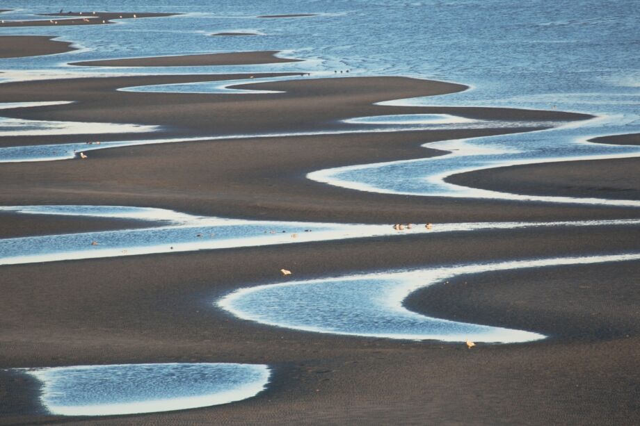 Photo montrant différents cours d'eau et flaques sur une plage - Photo de elvira Butler sur https://unsplash.com/fr/photos/une-plage-avec-de-nombreuses-petites-piscines-deau-yYZq06JAEoE