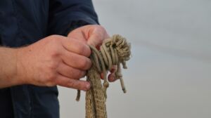 Un pêcheur démêle une corde - Photo de Hilde Demeester sur https://unsplash.com/fr/photos/personne-tenant-une-corde-brune-pendant-la-journee-f-HE43QLqCE