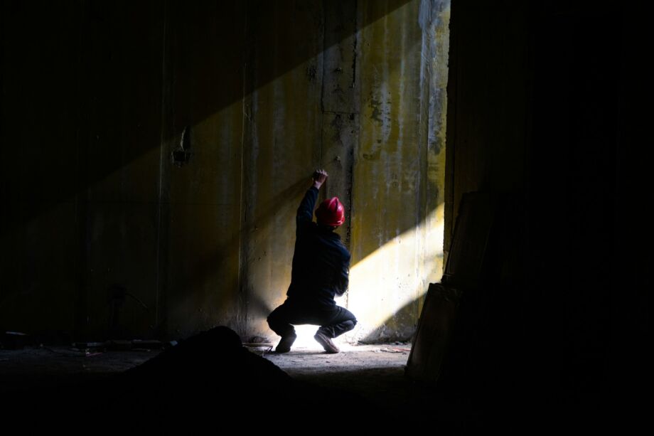 une personne accroupie face à un mur gris est levée par un rai de lumière - Photo de Yk Ksur https://unsplash.com/fr/photos/une-personne-agenouillee-dans-un-tunnel-sombre-JhNVif4yJpw