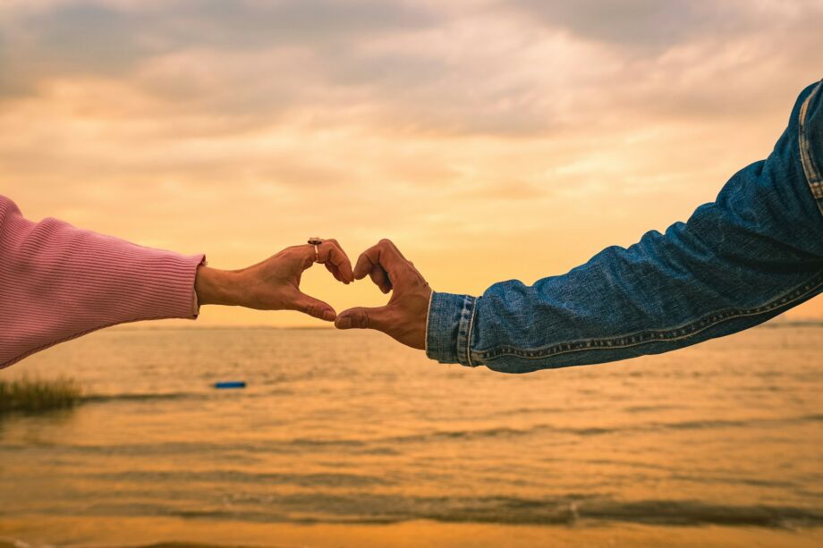 Les bras de deux amoureux forment à tous les deux un cœur avec leurs mains sur fond de coucher du soliel sur la mer - Photo de Henry Lai sur https://unsplash.com/fr/photos/deux-personnes-faisant-une-forme-de-coeur-avec-leurs-mains-Y4bTfD2Qrko